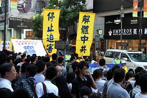 游行队伍经过九龙区闹市,沿途吸引很多人驻足观看。