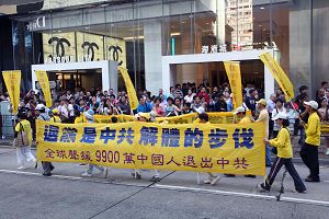 游行人士排成方阵,手持“退党是解体中共的步伐”横幅,在繁忙的市区经过。